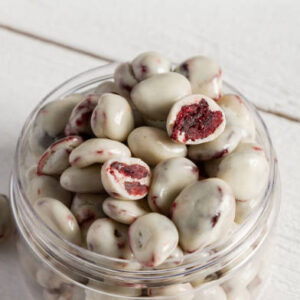 Dried fruits and berries in chocolate on a white wooden background. close up.
